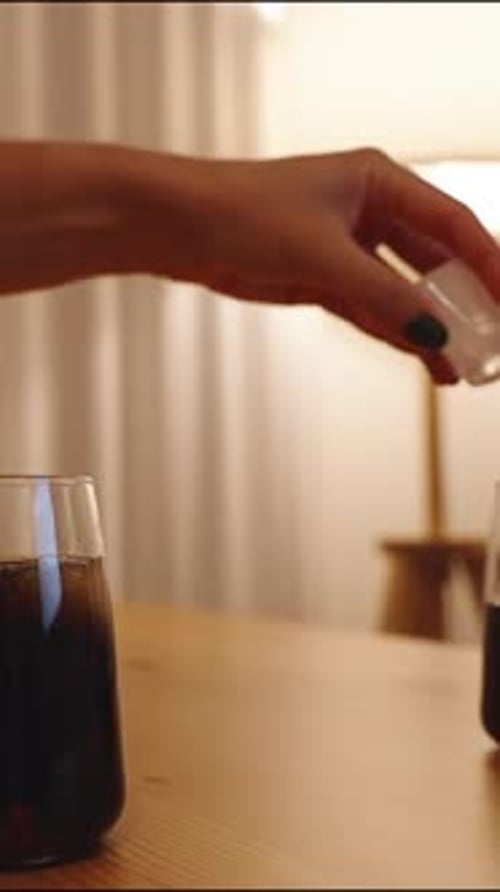 Pouring Ice into Glass of Soda