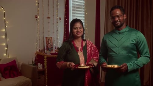 Couple Smiling Holding Food for Diwali Celebration