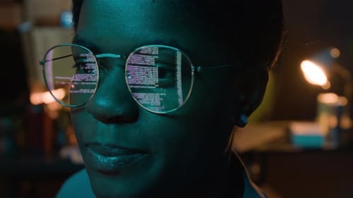 Black Female Software Developer Coding with Screen Reflection in Glasses