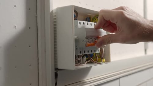 Electrician assembles electrical panel.