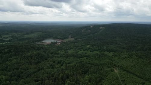 Stunning Aerial View of a Lush Green Forest Surrounded By Majestic Mountain Landscape Clip