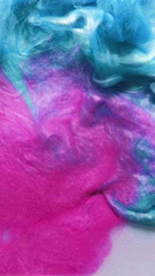 Iridescent Blue and Pink Paint Slowly Swirls