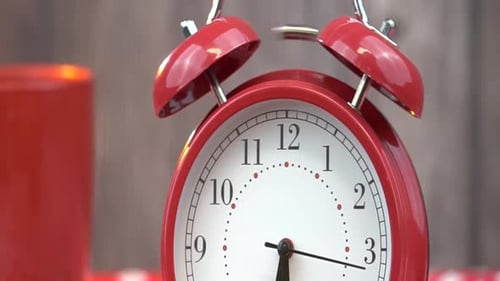 Close up of a red alarm clock ringing
