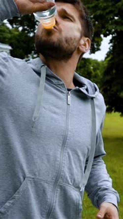 Man Drinks Water Outside in Nature