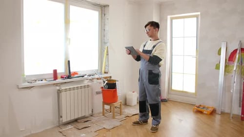 Man Using Tablet in Renovated Room