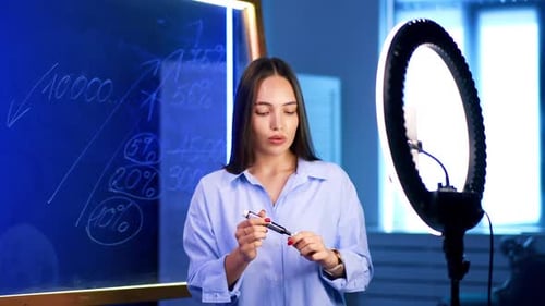 Woman Explaining Finance Near a Ring Light