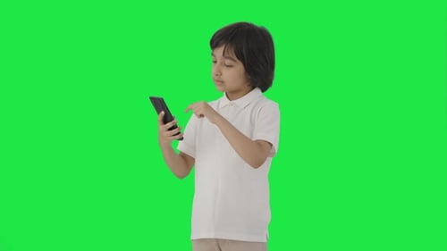Indian boy scrolling through phone Green screen