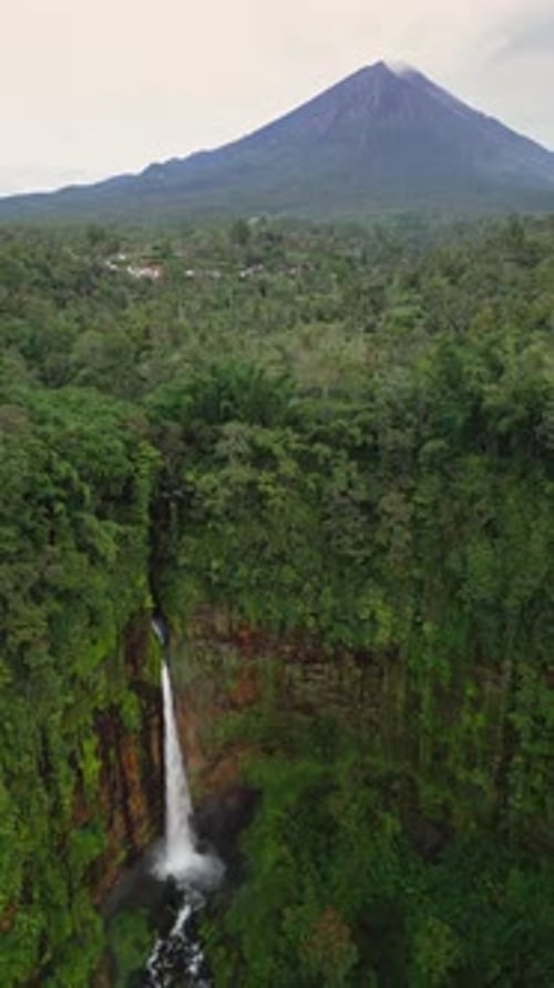 Vidéo par Drone vertical d'une puissante cascade indonésienne près du volcan Semeru capturée d'en haut