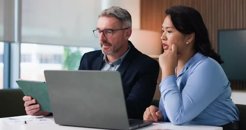 Professionals Discussing Business Using Laptop and Tablet Indoors