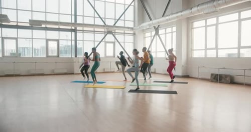 Group of Beginners Warms Muscles Running in Place on Mat