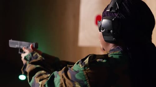 Woman Aims Handgun at Target in Shooting Range