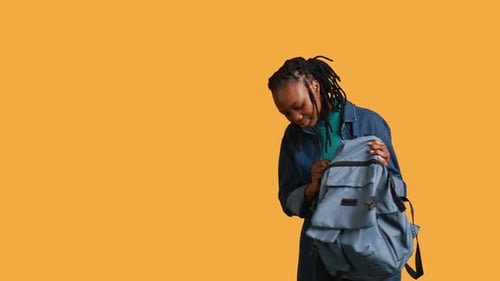 Girl Taking Out Business Class Materials Out of Rucksack Studio Background