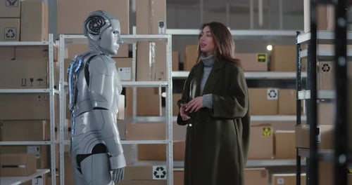 Woman Interacting with Futuristic Robot in Warehouse