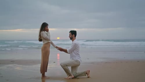 Man Proposes to Woman at Sunset on Beach