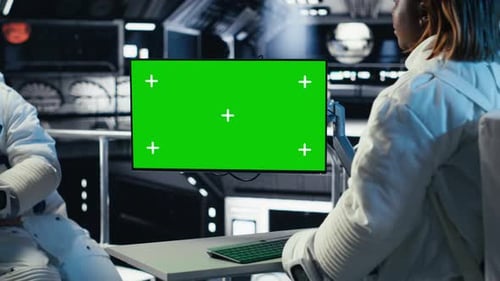 Astronaut Reviewing Onboard Analytics on Green Screen Monitor