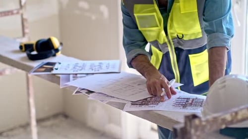 Architekt überprüft Projektpapiere und Dokumente steht im Zimmer