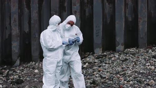 Forensiker untersucht Probe am Flussufer