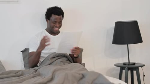 Adult Celebrates Good News in Bed at Home