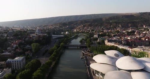 Cinematic Aerial View Above Kura River in Downtown Tbilisi, Georgia. Sunrise