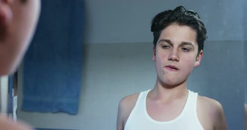 sehr netter Teenager im Badezimmer in sanfter Zeitlupe.