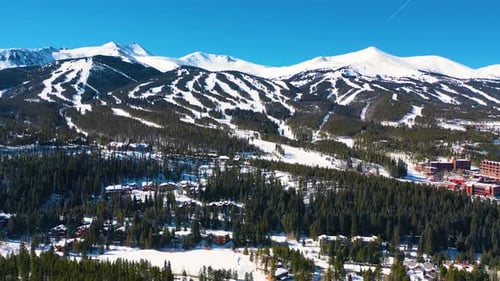 Ski Slope Trails on top of Beautiful Mountains Covered in White Powder Snow. Aerial Drone View of Co
