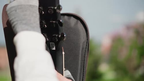 Musicians Hand Opening Guitar Case in Sunlit Park Fingerless Glove Brown Leather Exterior Zipper
