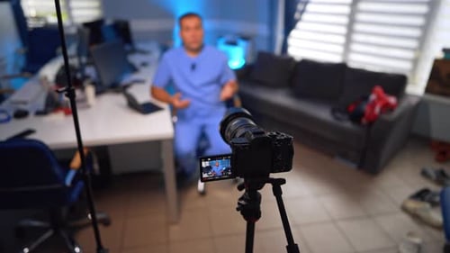 Doctor in his office records a video for the blog on the professional camera.