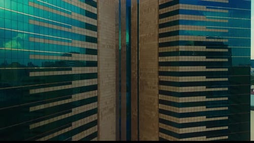Drone View of Modern Glass Skyscraper with Sunlit Reflections Office Building Aerial Elevator Shot