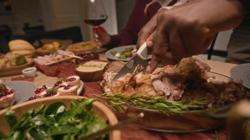 Mains d'un homme servant de la dinde dans des assiettes d'amis célébrant le jour de Thanksgiving