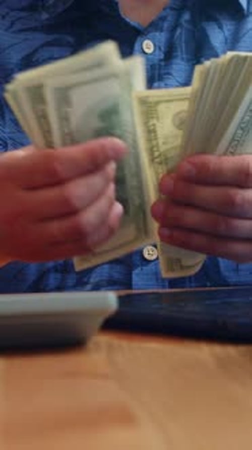 Vertical Clip Of Man Counting US Dollar Cash Close Up Finance And Money Concept