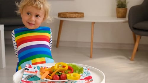 Child Looking at Plate of Colorful Cut Vegetables
