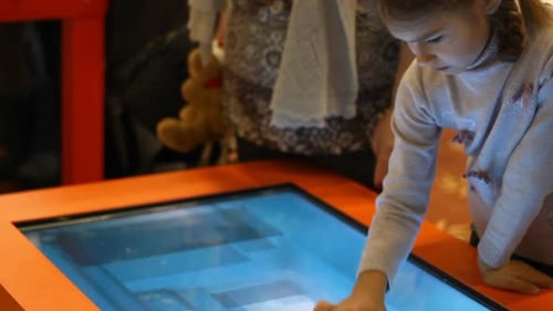 Girl Playing Video Game on Big Touch Screen Computer. Girl Kid Playing