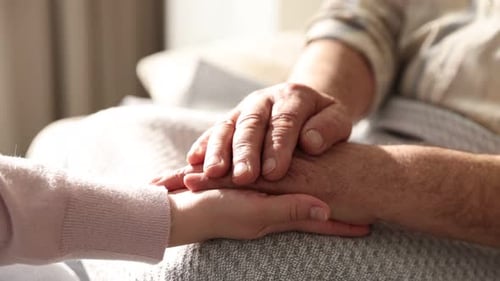 Großvater und Enkelin halten sich zu Hause an den Händen, Nahaufnahme. Kamera bewegt sich vorwärts und rückwärts