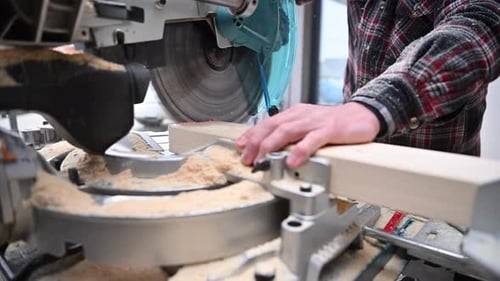 Carpenter Cutting Wooden Beam with Table Saw