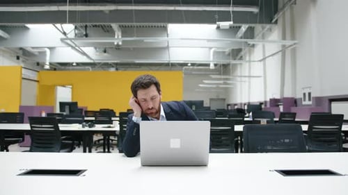 Porträt eines erschöpften und gestressten Geschäftsmannes, der im modernen Büro zu viel arbeitet