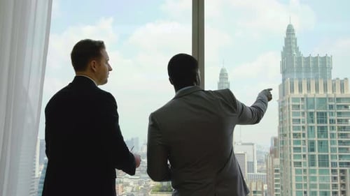 Two business people talk project strategy at office meeting room.