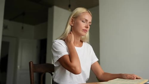 Woman Massaging Neck for Pain Relief at Home