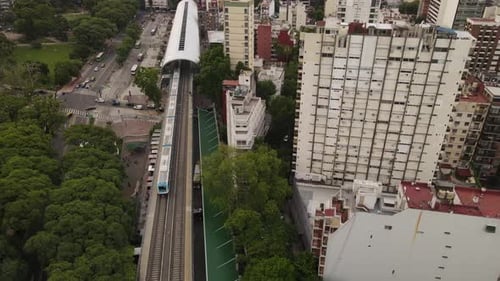Train arriving at Barrancas of Belgrano station in Buenos Aires. Aerial top-down forward