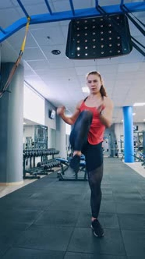 Front view of a sportswoman indoors. Sportive girl training her body in fitness centre.