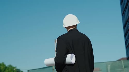 portrait of a successful handsome engineer, architect, builder, businessman in a white helmet, in a
