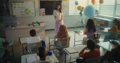 Female Teacher Educating Ecology to Smart Kids Primary School Children Raising Hands to Give Answer