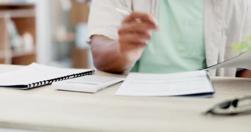 Hand Using Calculator and Writing in Notepad