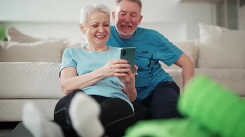Senior Couple Using Smartphone After Exercising