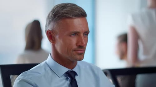 Thoughtful businessman breathing deeply in modern office posing for portrait