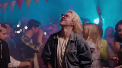 Enthusiastic Crowd Dancing at Lit Up Party Venue