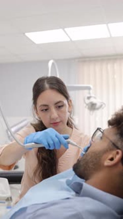 Dentist Examining Patient in Dental Office