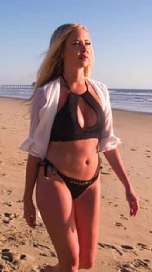 Attractive Blond Woman Walking on the Beach. Vertical Video.