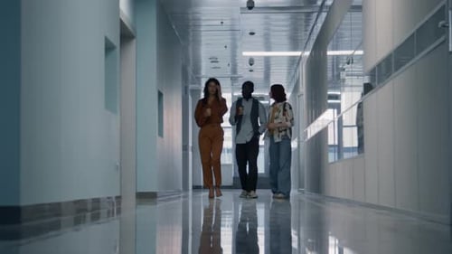 Colleagues Walking Along Office Corridor