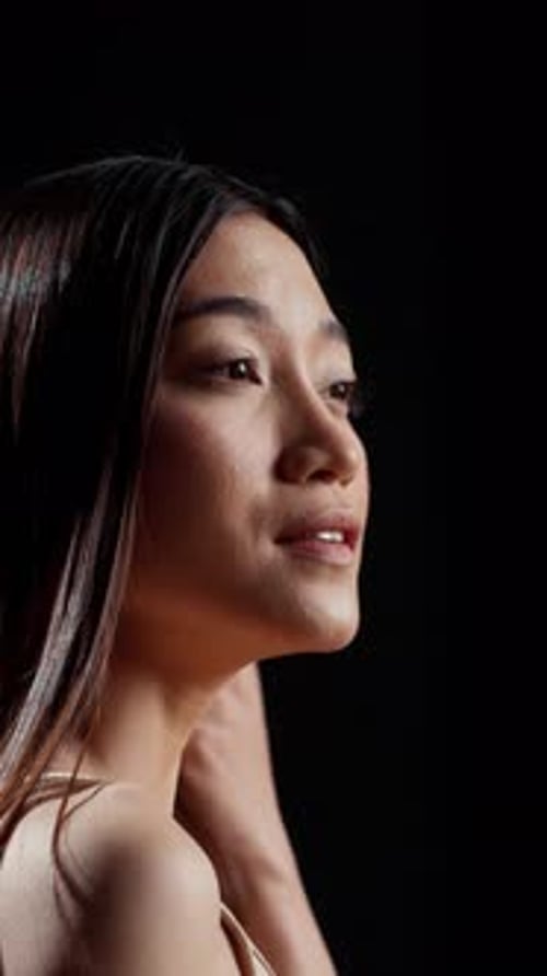 Elegant Woman Touching Hair in Studio, Close Up