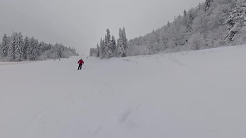 Person Skiing Down Empty Snowy Mountain Slope Winter Landscape View
